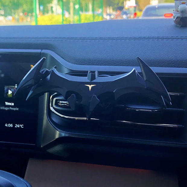 Eprolo Batman Gravity Buckle Car Phone Holder in use on a car dashboard, showcasing its unique bat silhouette while securely holding a phone.